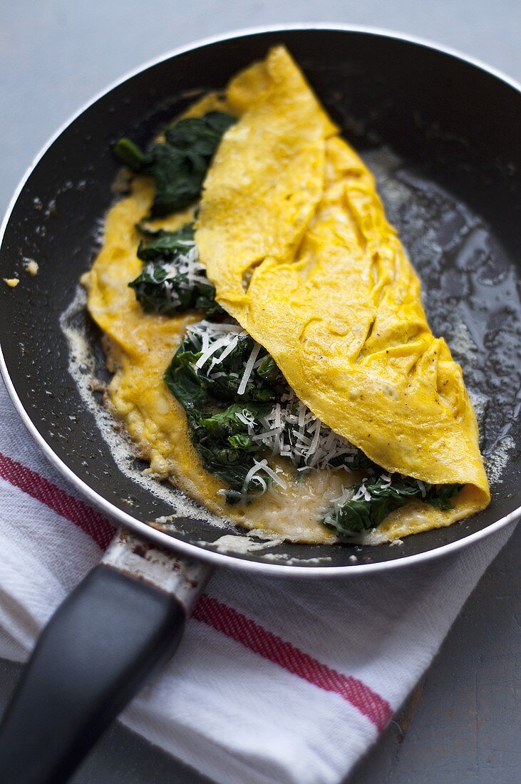 Spinach and Parmesan omelette in frying pan