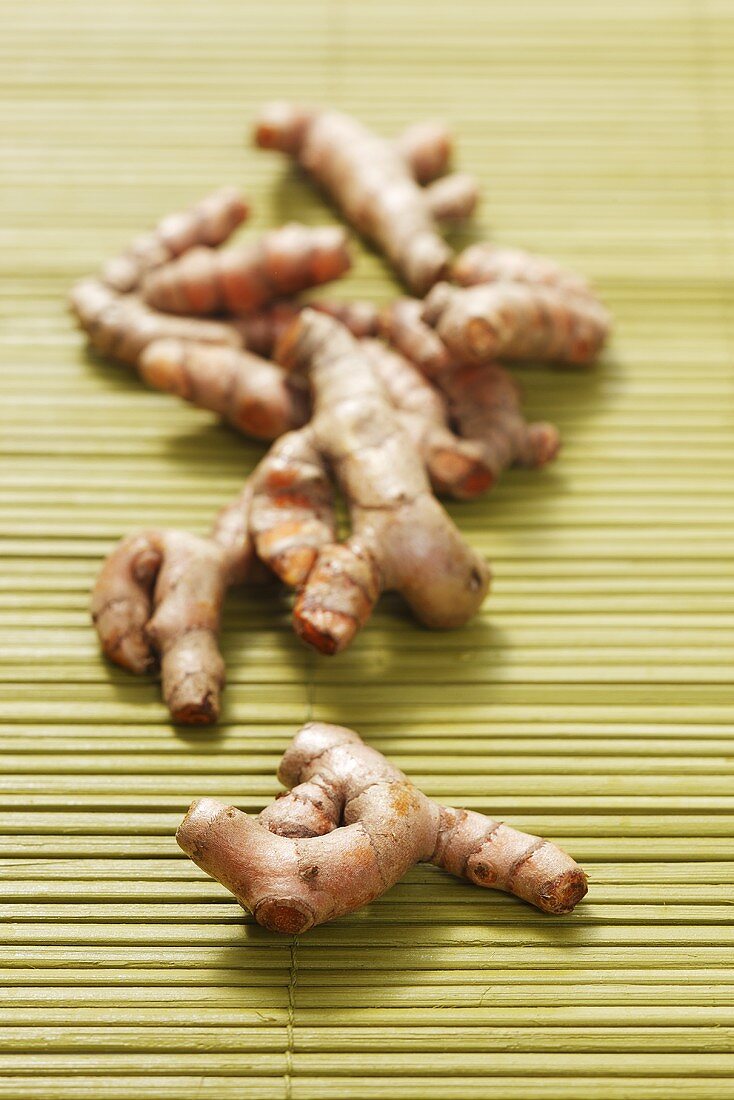 Fresh turmeric roots on bamboo mat