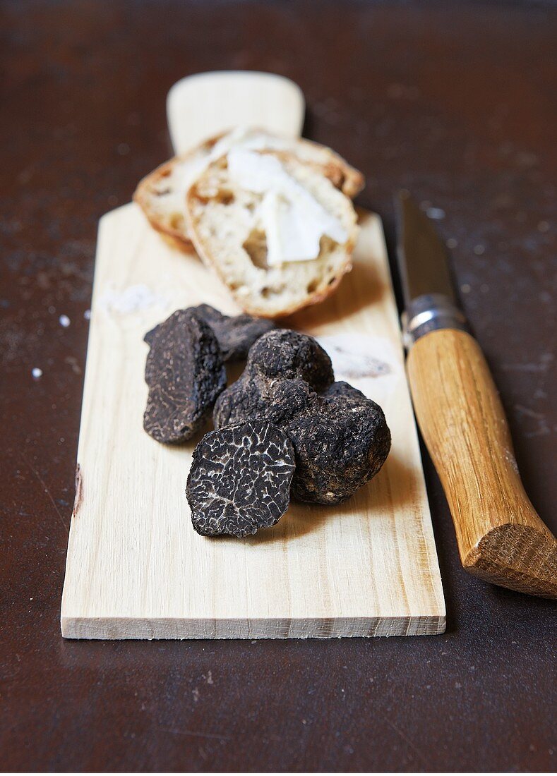 Black truffles on a wooden board