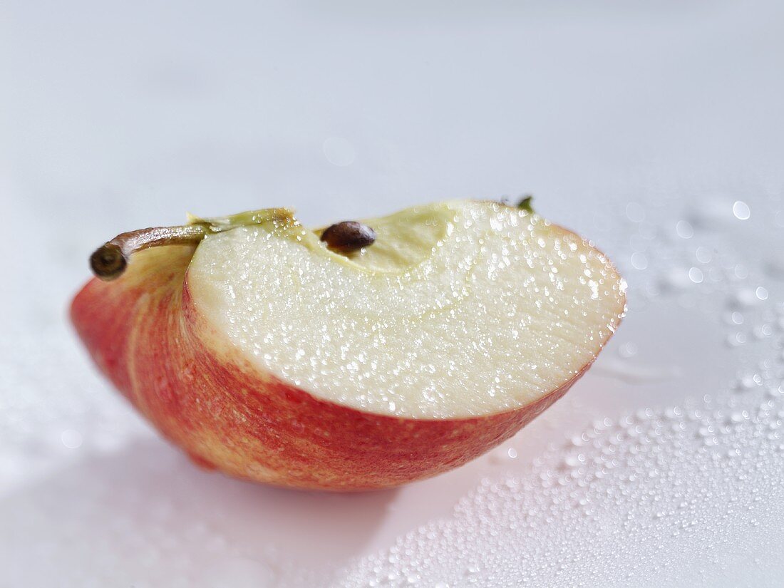 Wedge of apple with drops of water