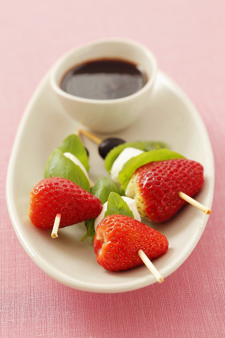 Strawberries, mozzarella, olives and basil on cocktail sticks