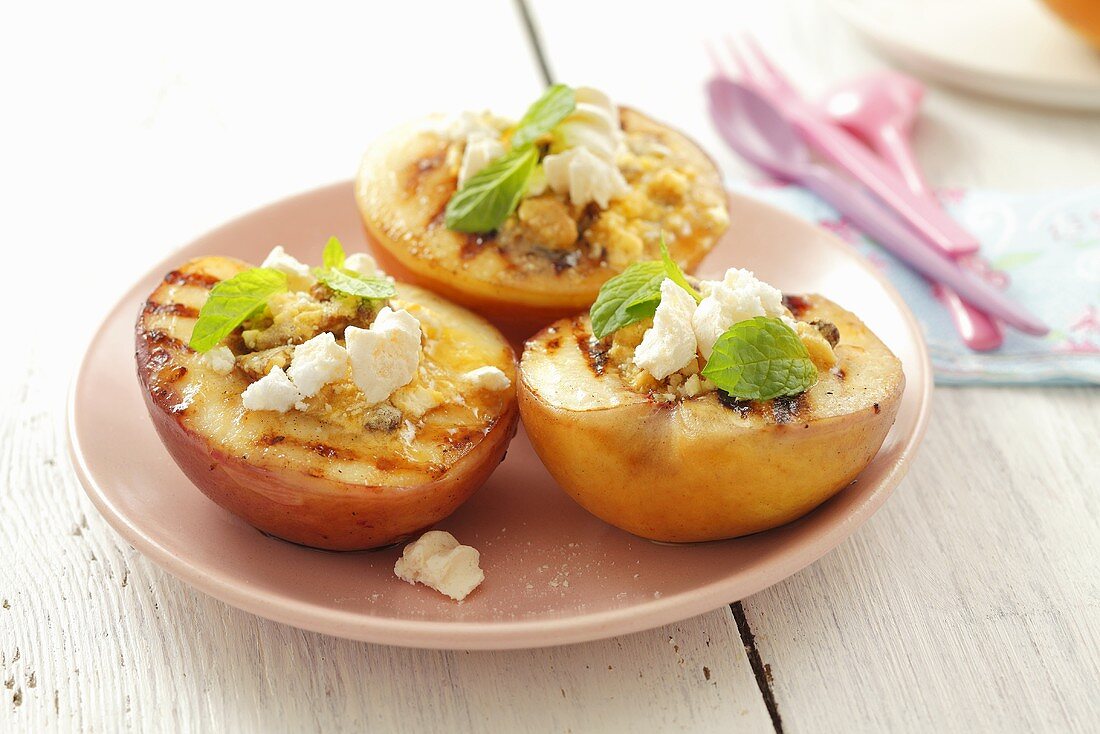 Baked peaches stuffed with meringue and mint leaves