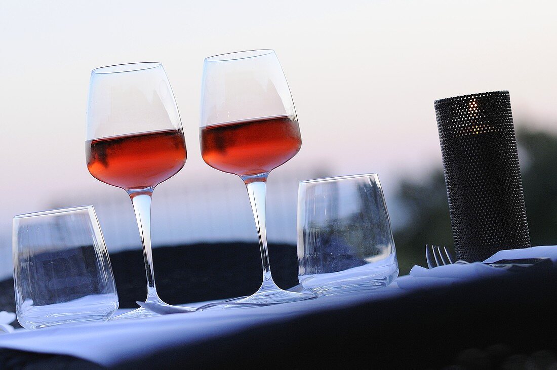 Glasses of rosé wine on laid table