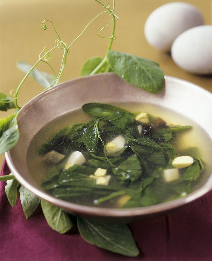 Clear broth with leafy vegetables and boiled eggs