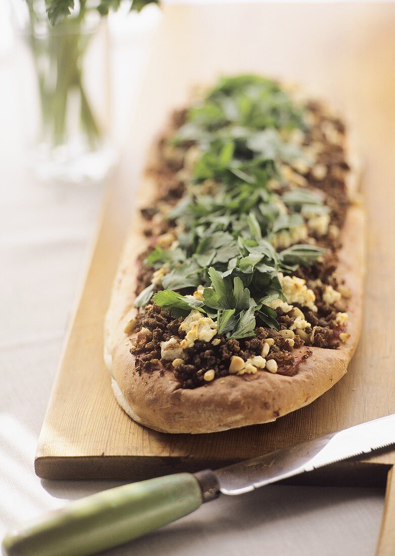 Wholemeal flatbread with minced lamb, sheep's cheese & parsley