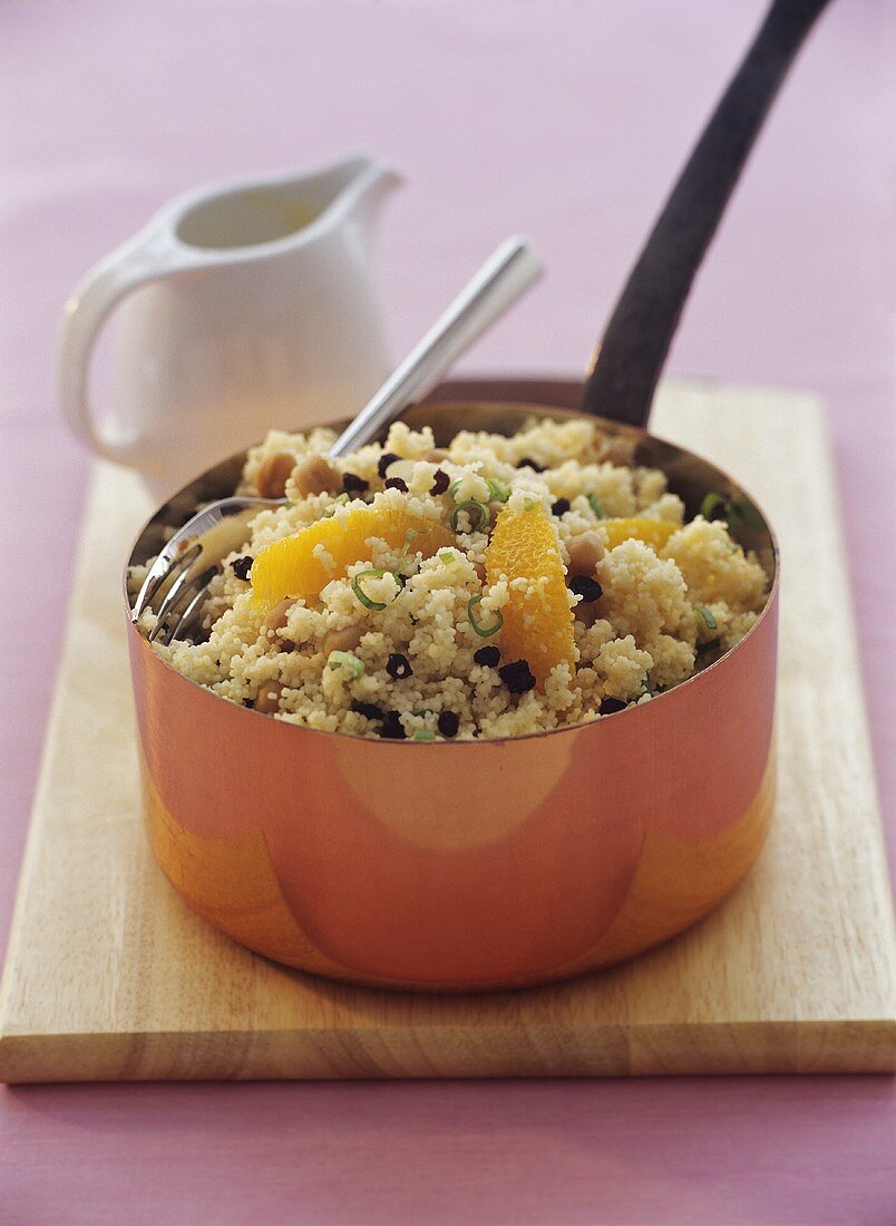 Couscous salad with orange segments and sultanas in pan