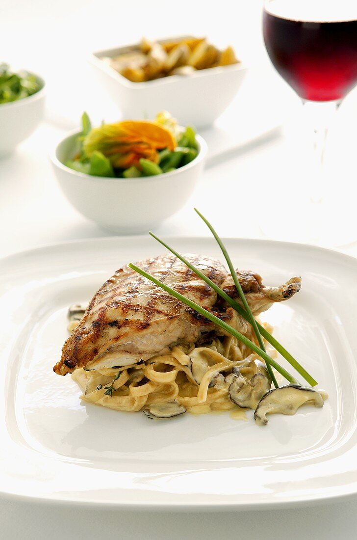 Grilled chicken breast on ribbon pasta with mushrooms
