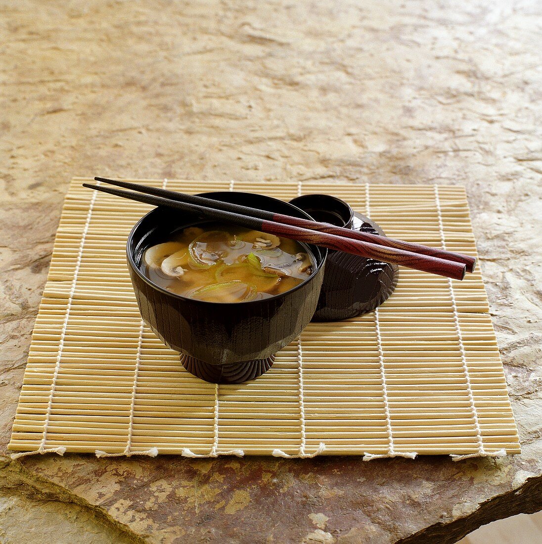 Miso-Suppe in schwarzem Schälchen