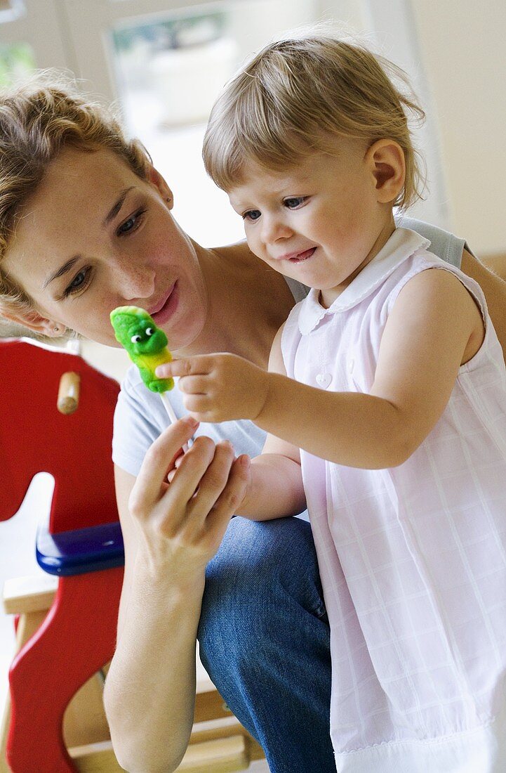 Mother giving her small daughter a lollipop