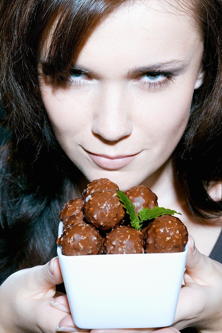 Young woman with bowl of chocolates