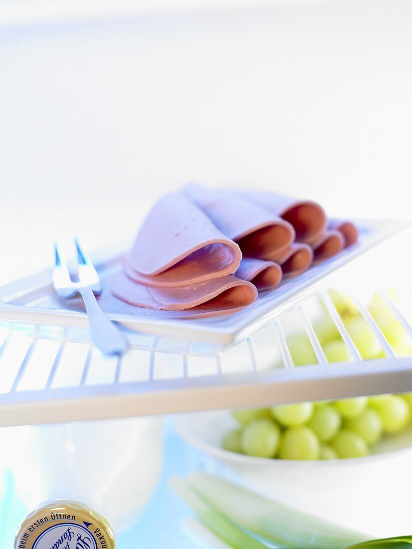 Slices of ring bologna on a plate in a fridge