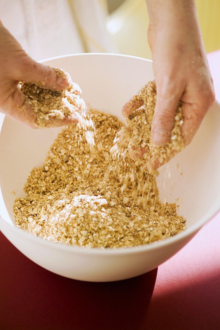 Putting oats into a bowl, for crumble