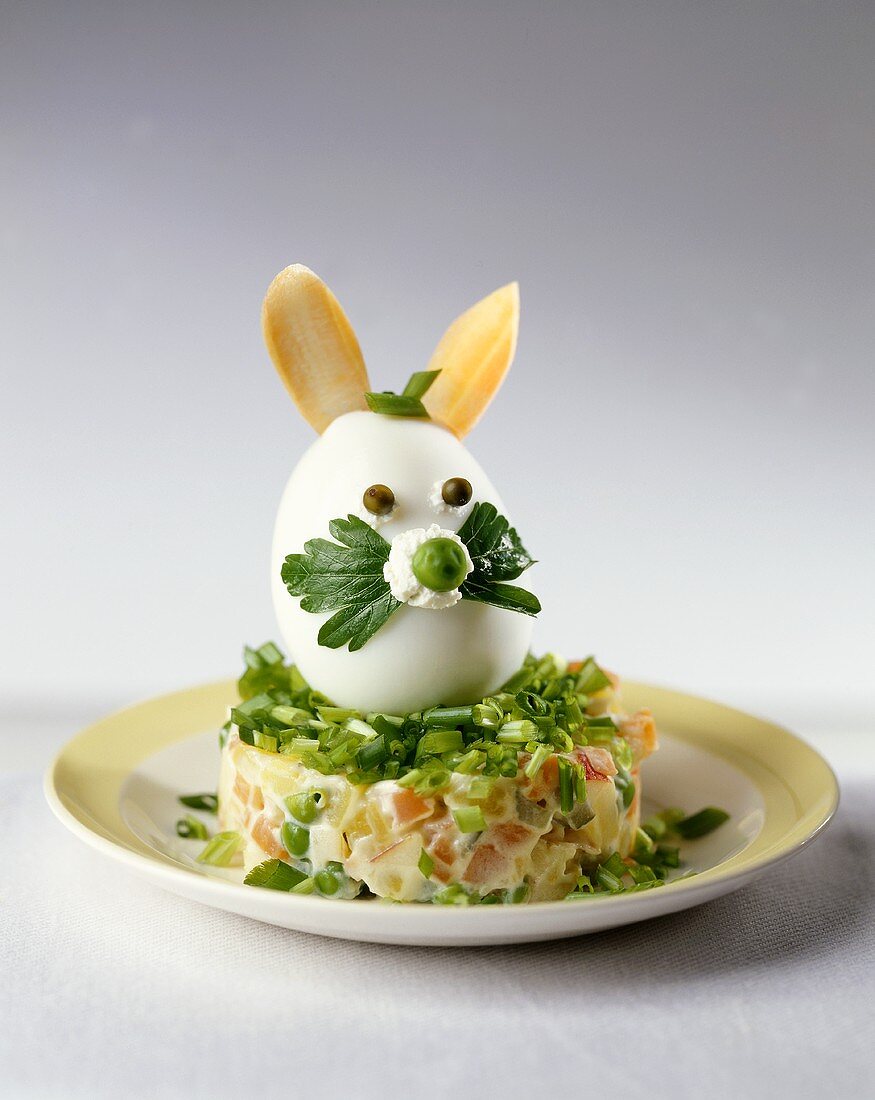 Boiled egg Easter Bunny on vegetable salad in mayonnaise