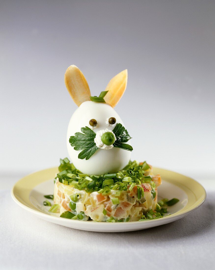 Gekochtes Ei als Osterhase auf Gemüse-Mayonnaise-Salat