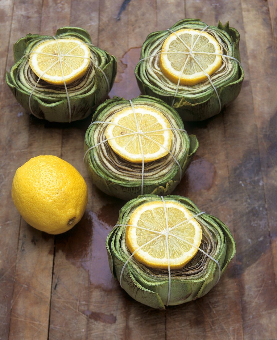 Artichokes with slices of lemon, ready to cook