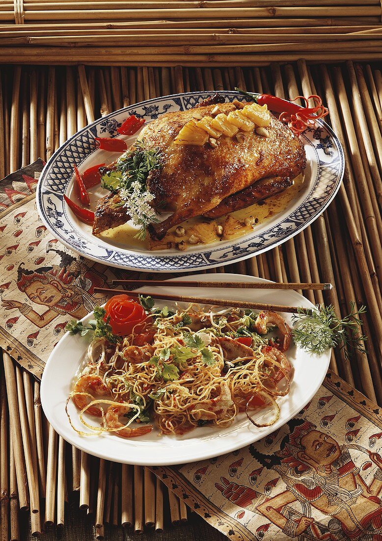 Two Asian dishes: roast duck and fried noodles