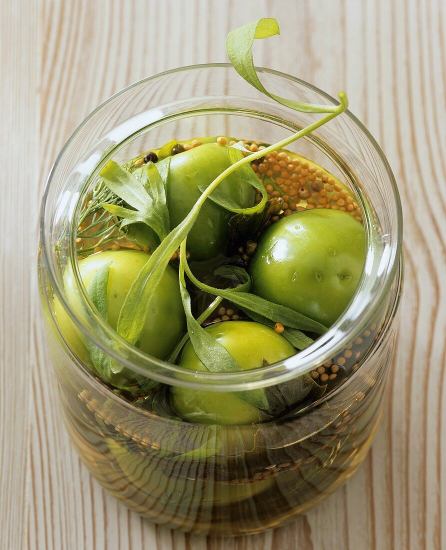 Pickled green tomatoes in preserving jar