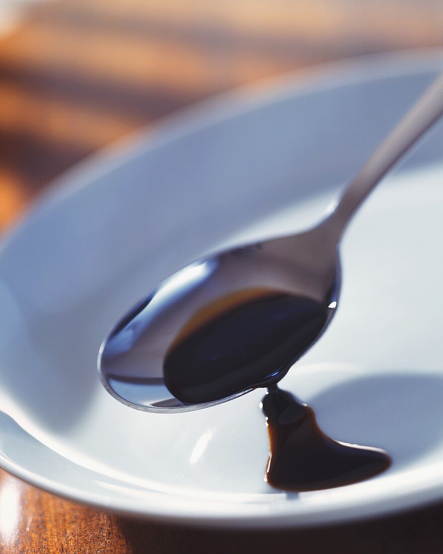 Balsamic vinegar in a spoon and on a plate