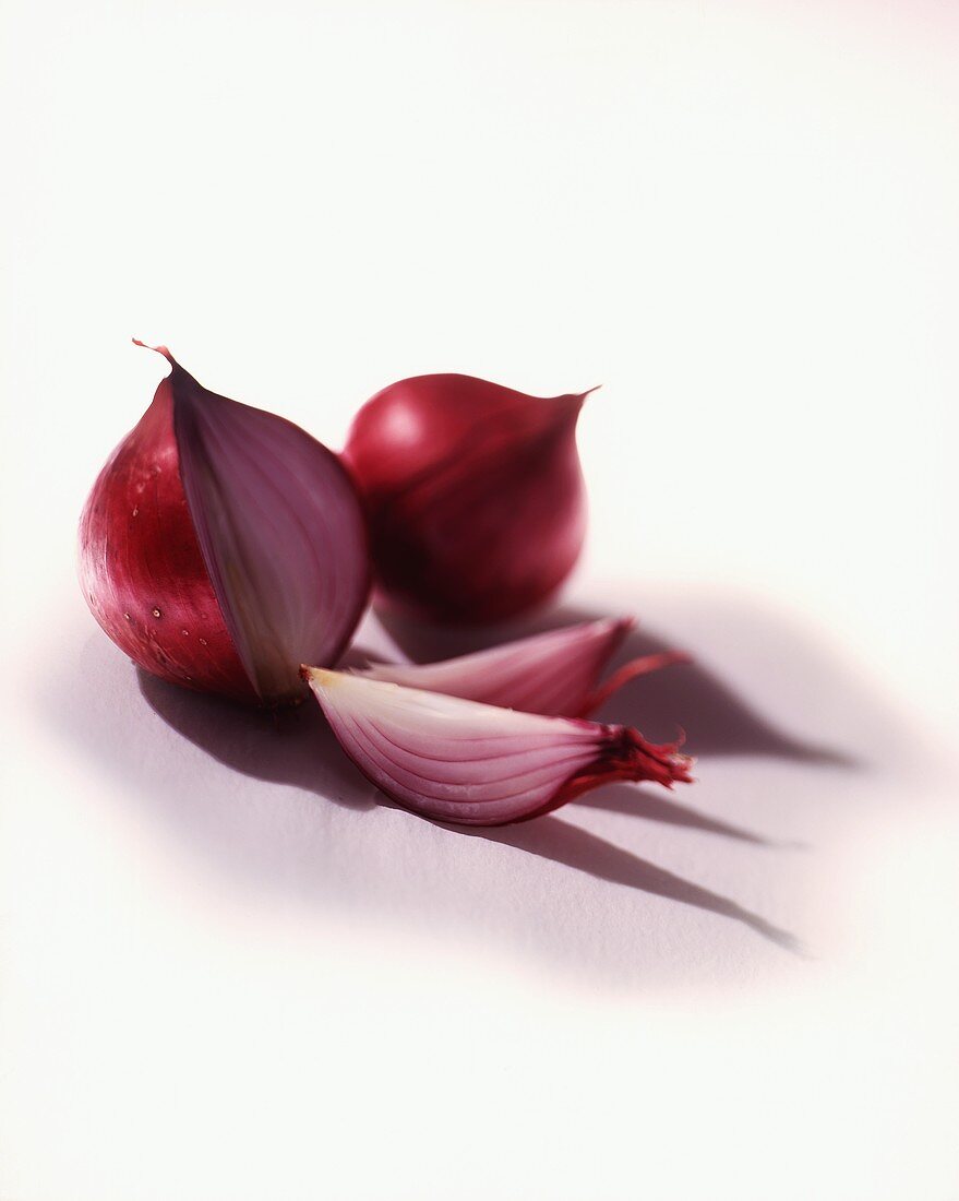 Two red onions, one cut open