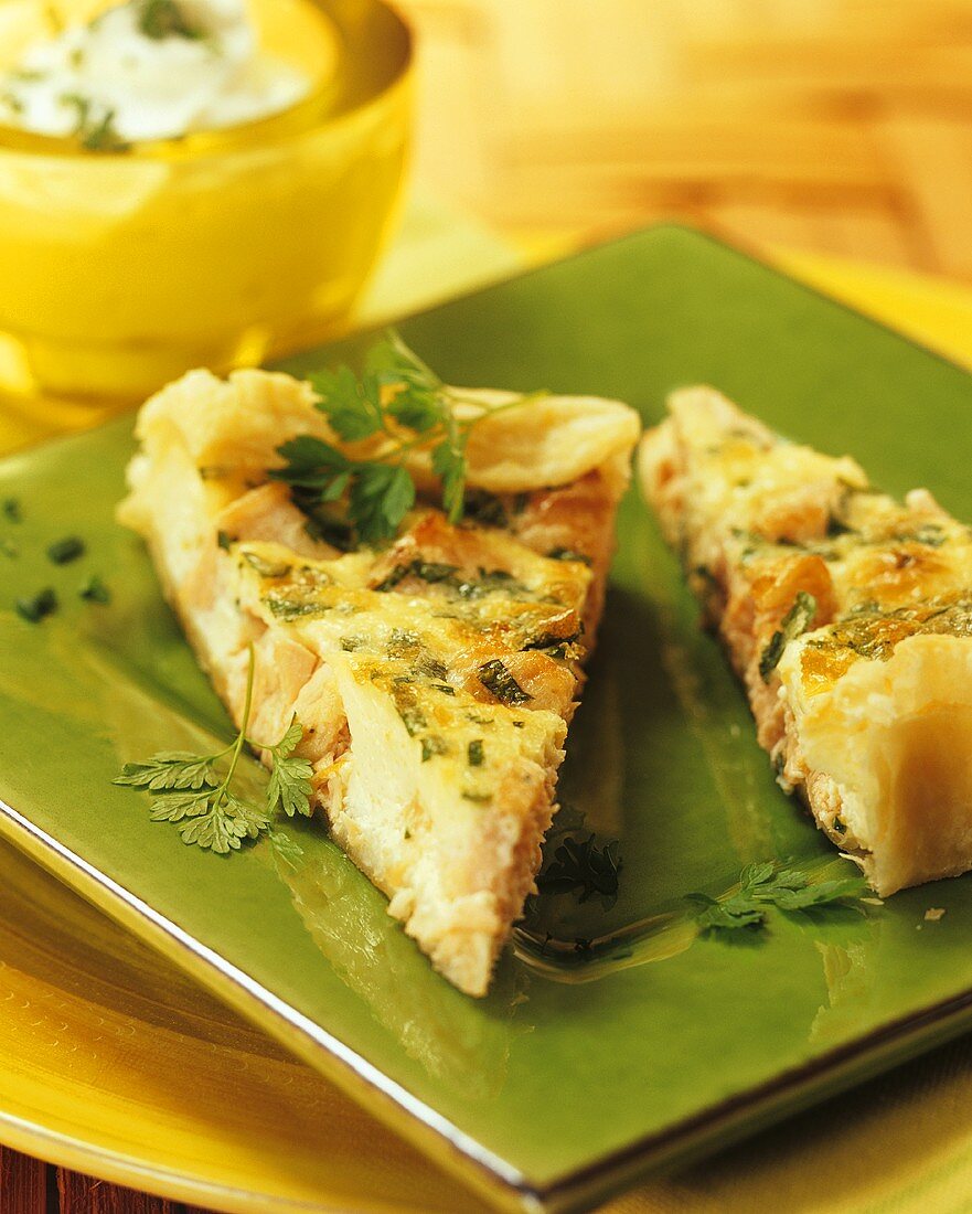 A piece of salmon and herb quiche on a plate