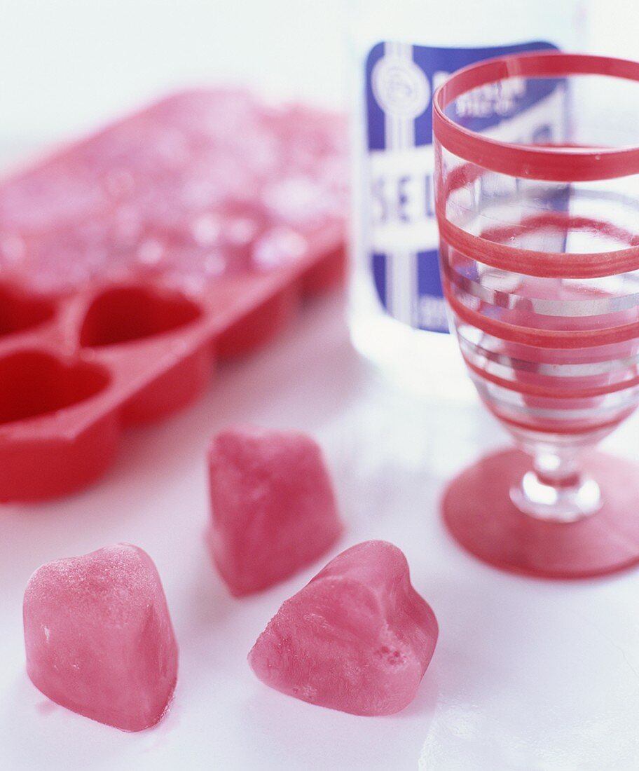 Red heart-shaped ice cubes, made from fruit juice