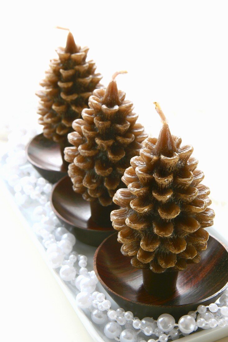 Three pine cone-shaped Christmas candles