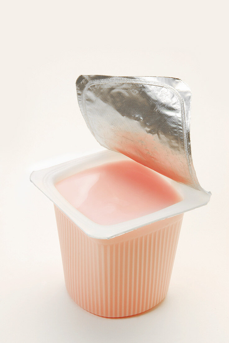 Strawberry yoghurt in opened yoghurt pot