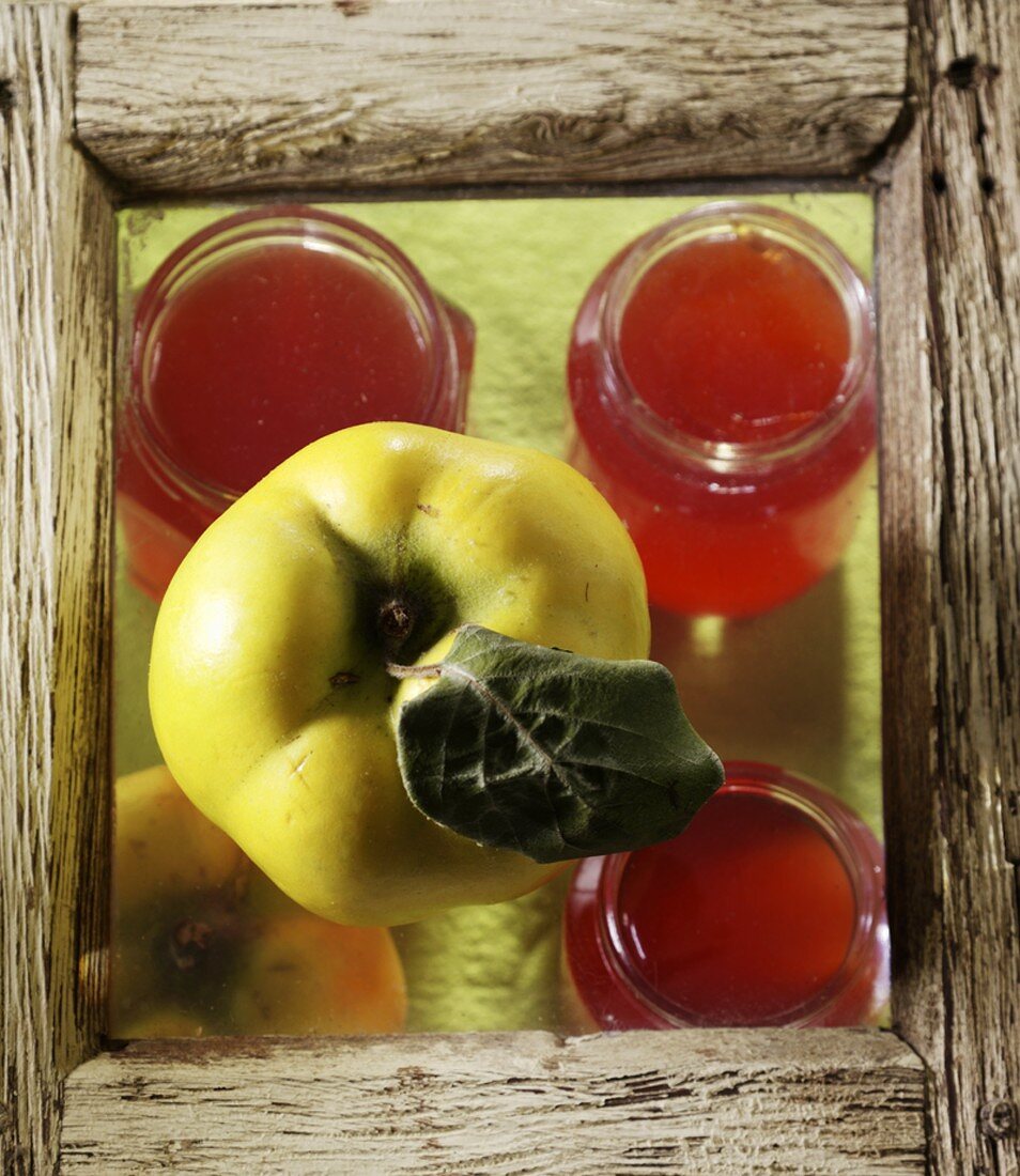 Three jars of quince jelly and a fresh quince