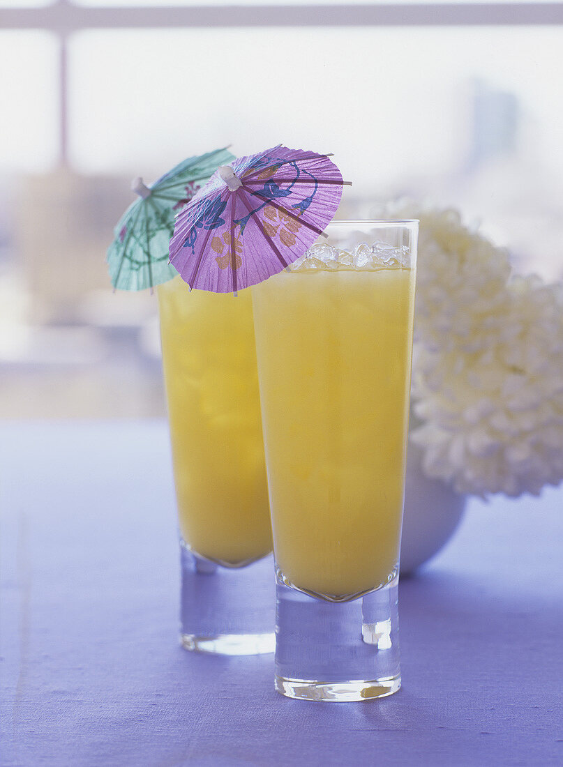 Orange Velvet in two glasses with cocktail umbrellas