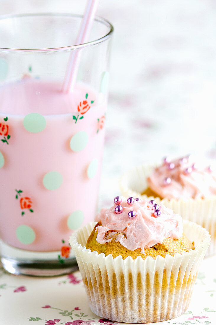 Fairy Cakes mit rosa Zuckerguss und ein Erdbeermilchshake