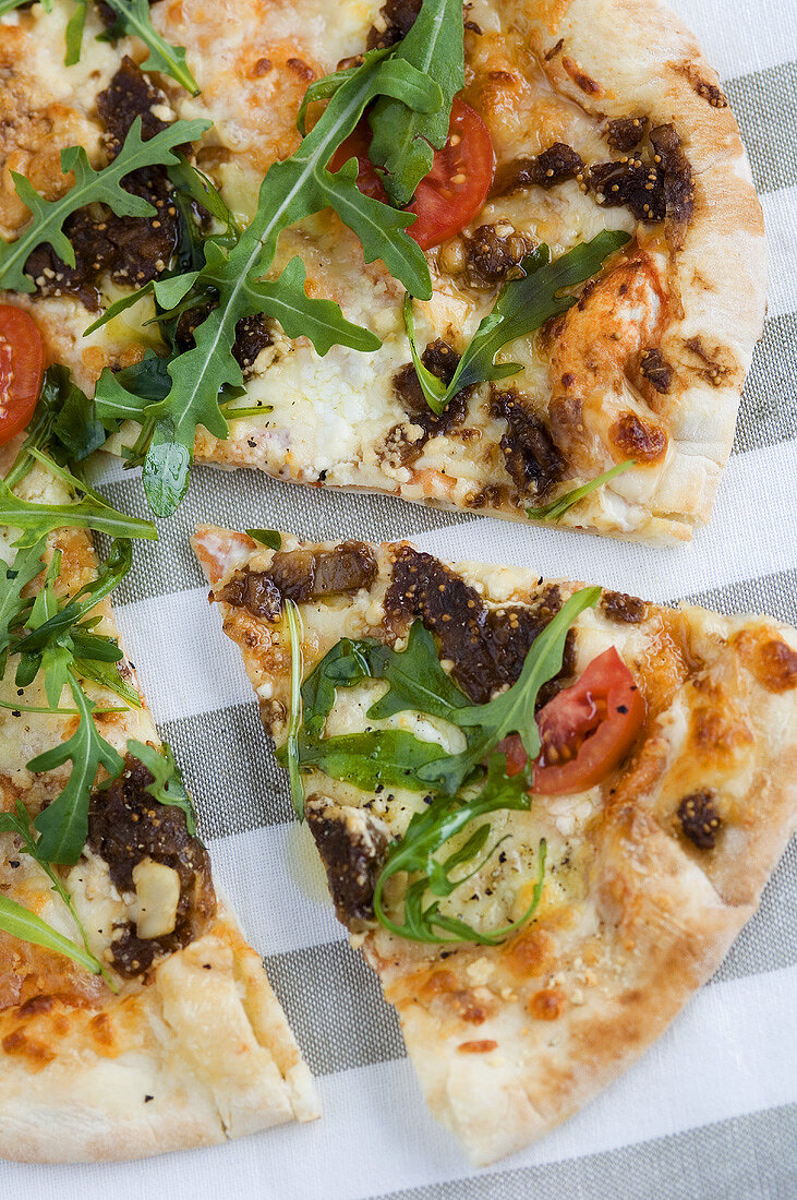 Pizza with rocket, fig, tomato and mozzarella topping