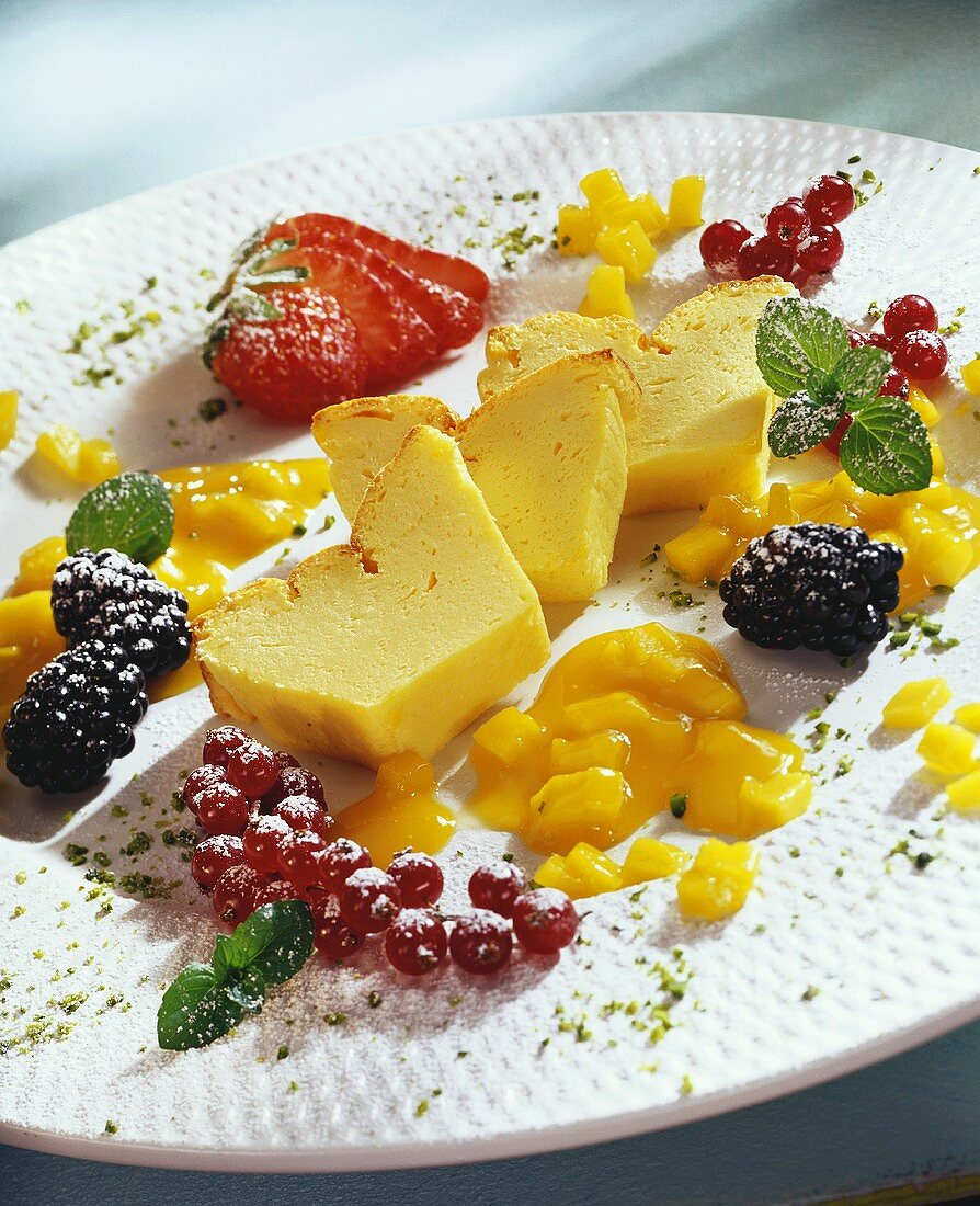 Slice of quark cake with mango sauce and fresh berries