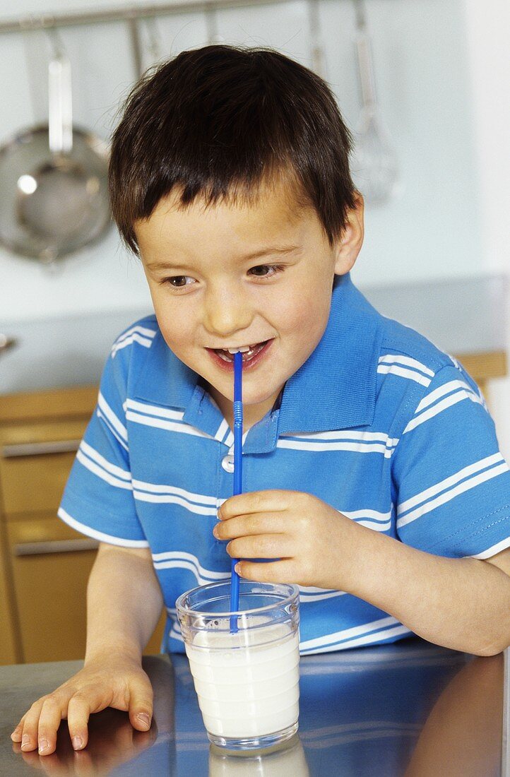 Kleiner Junge trinkt Milch mit Strohhalm