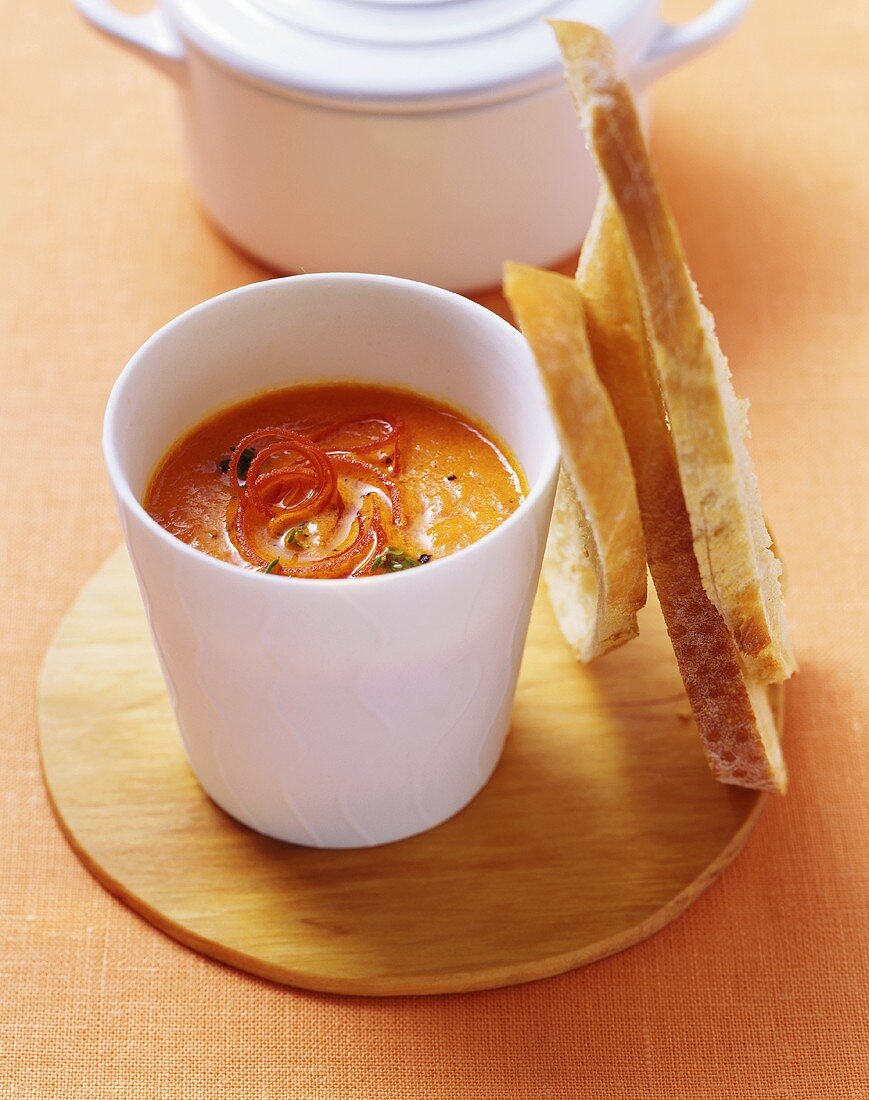 Red pepper soup with thyme in white beaker