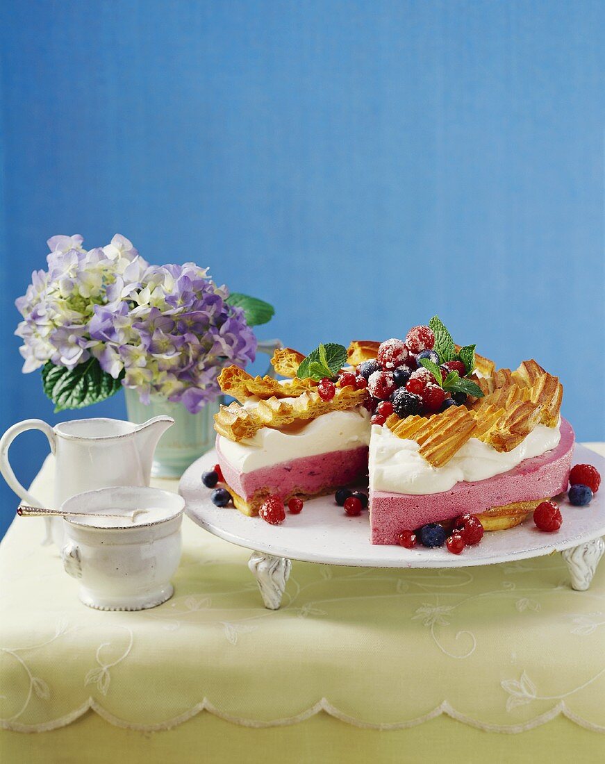 Beeren-Joghurt-Torte mit Sahne und Brandtteigverzierung