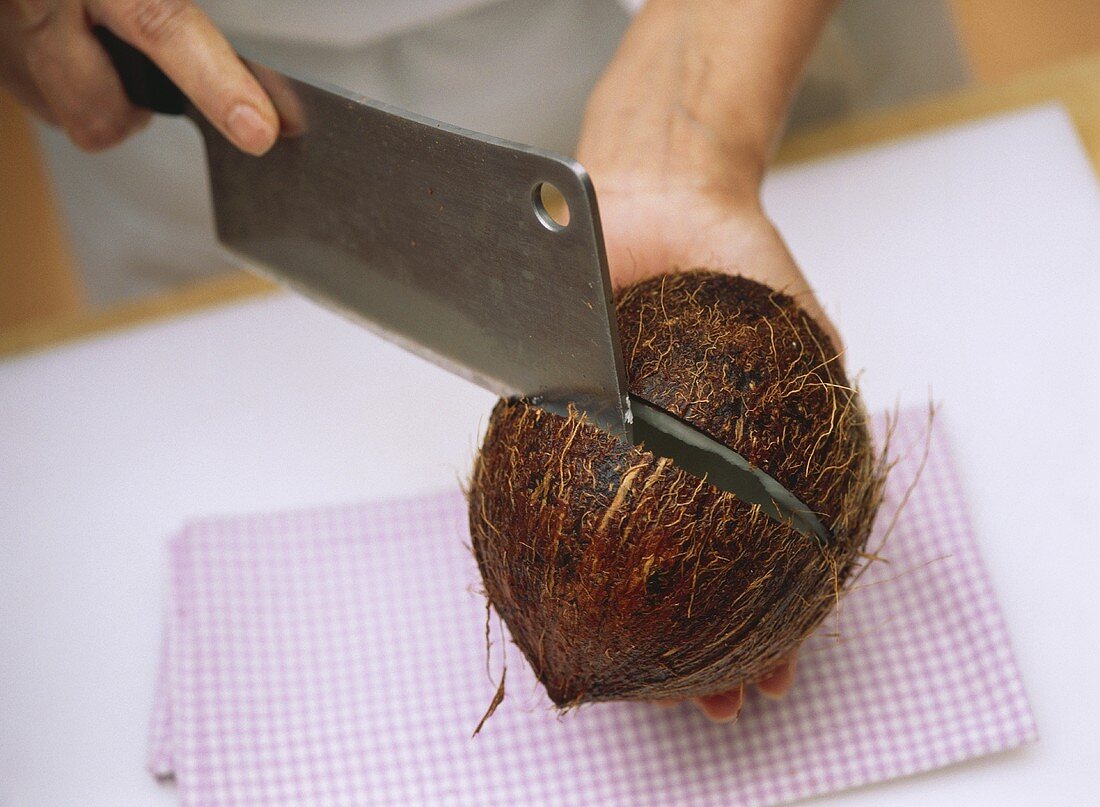 Kokosnuss mit einem Küchenbeil zerteilen