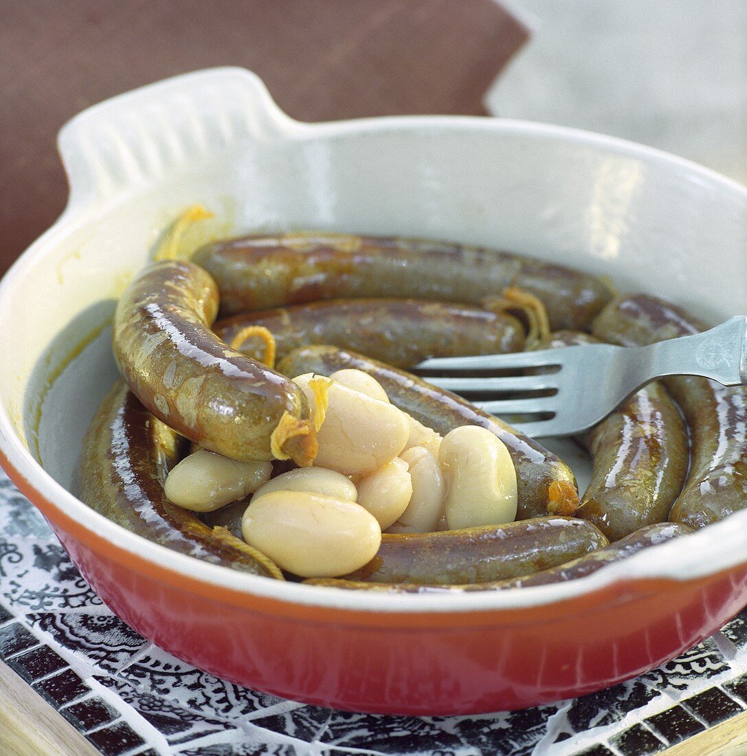 Bratwürste mit weissen Bohnen in einer Backform