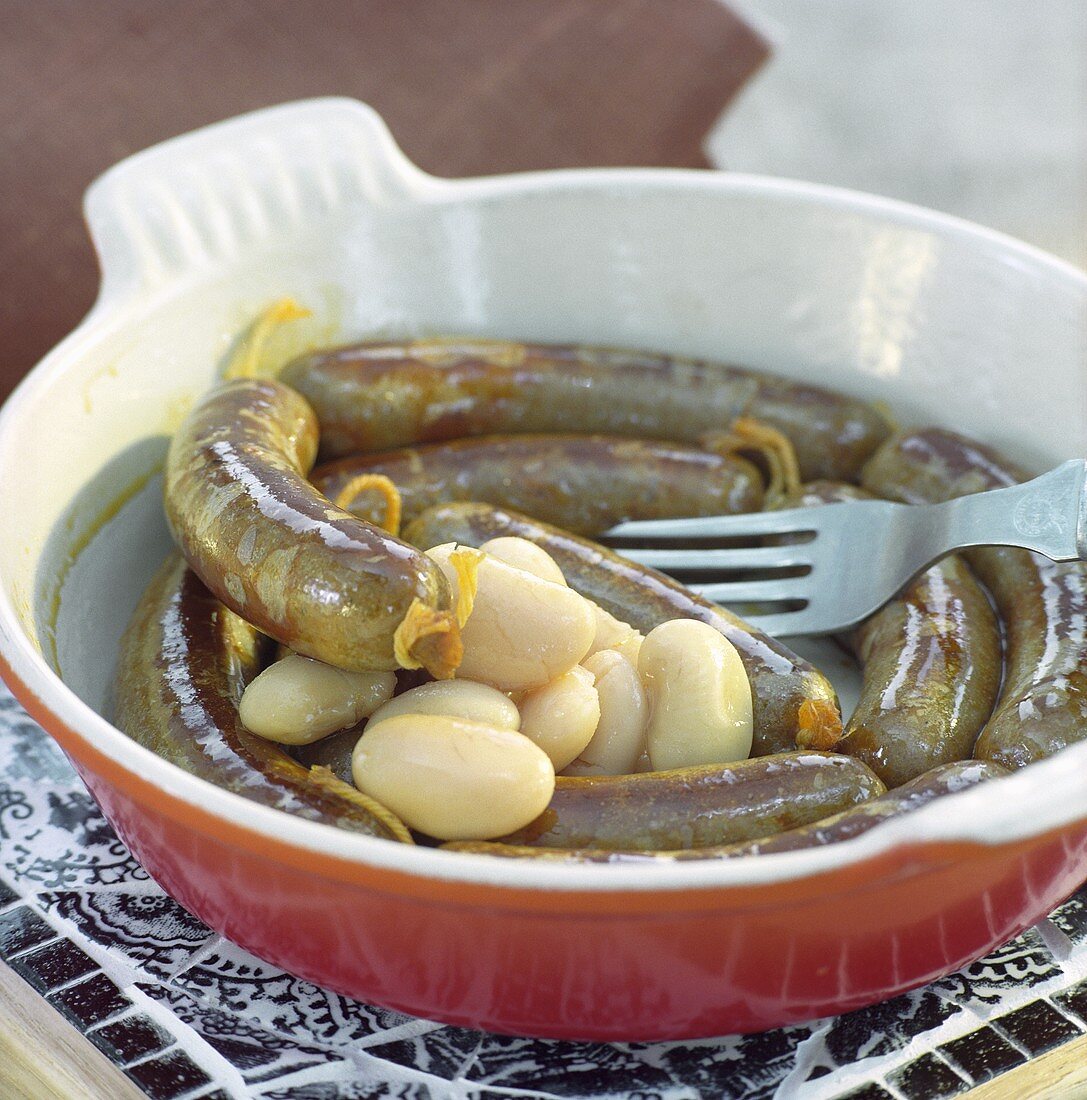 Sausages and white beans in a baking dish