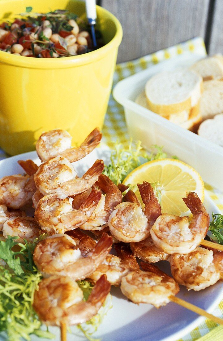 Shrimp skewers, slices of white bread, picnic salad