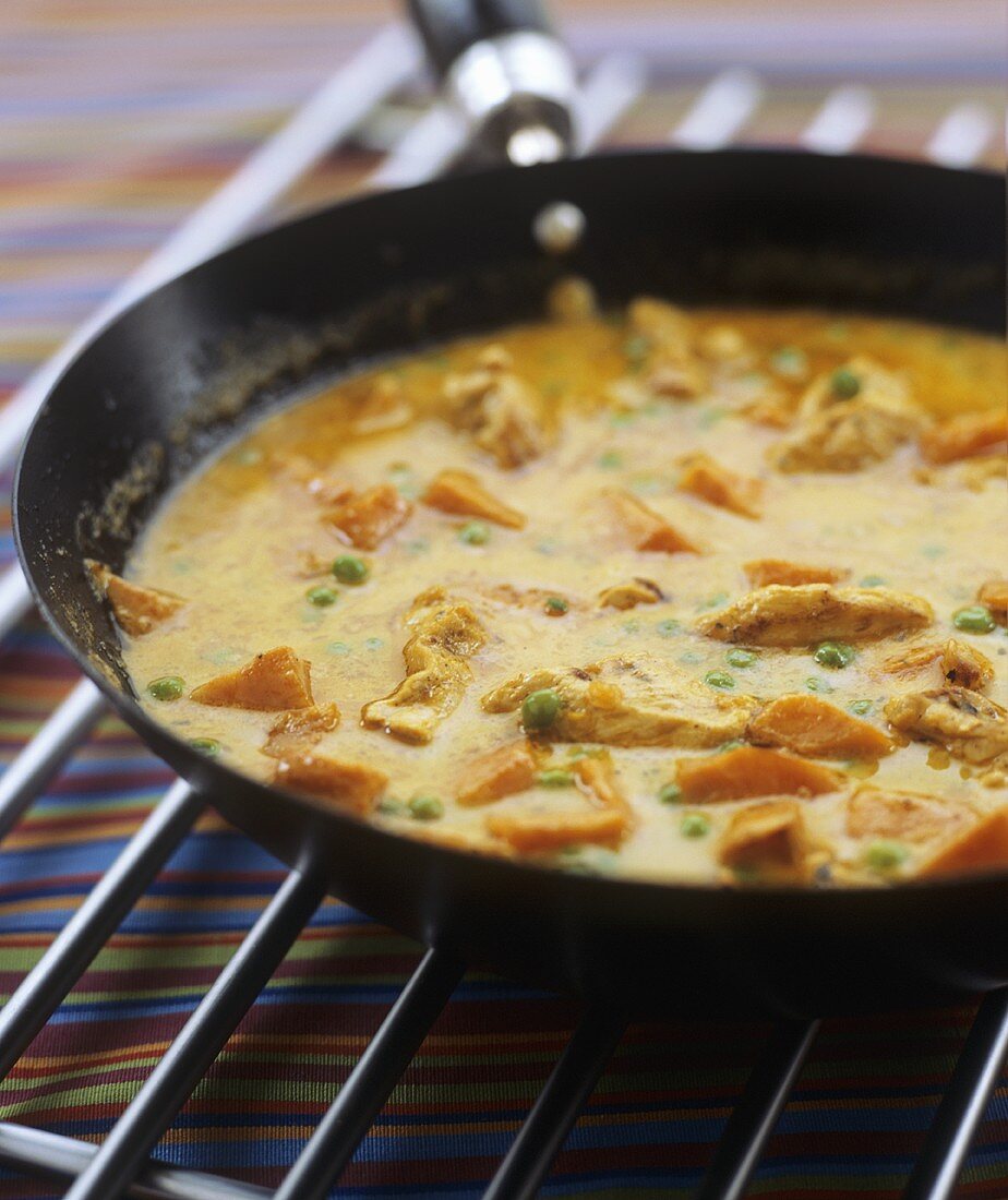 Chicken and sweet potato curry in a frying pan