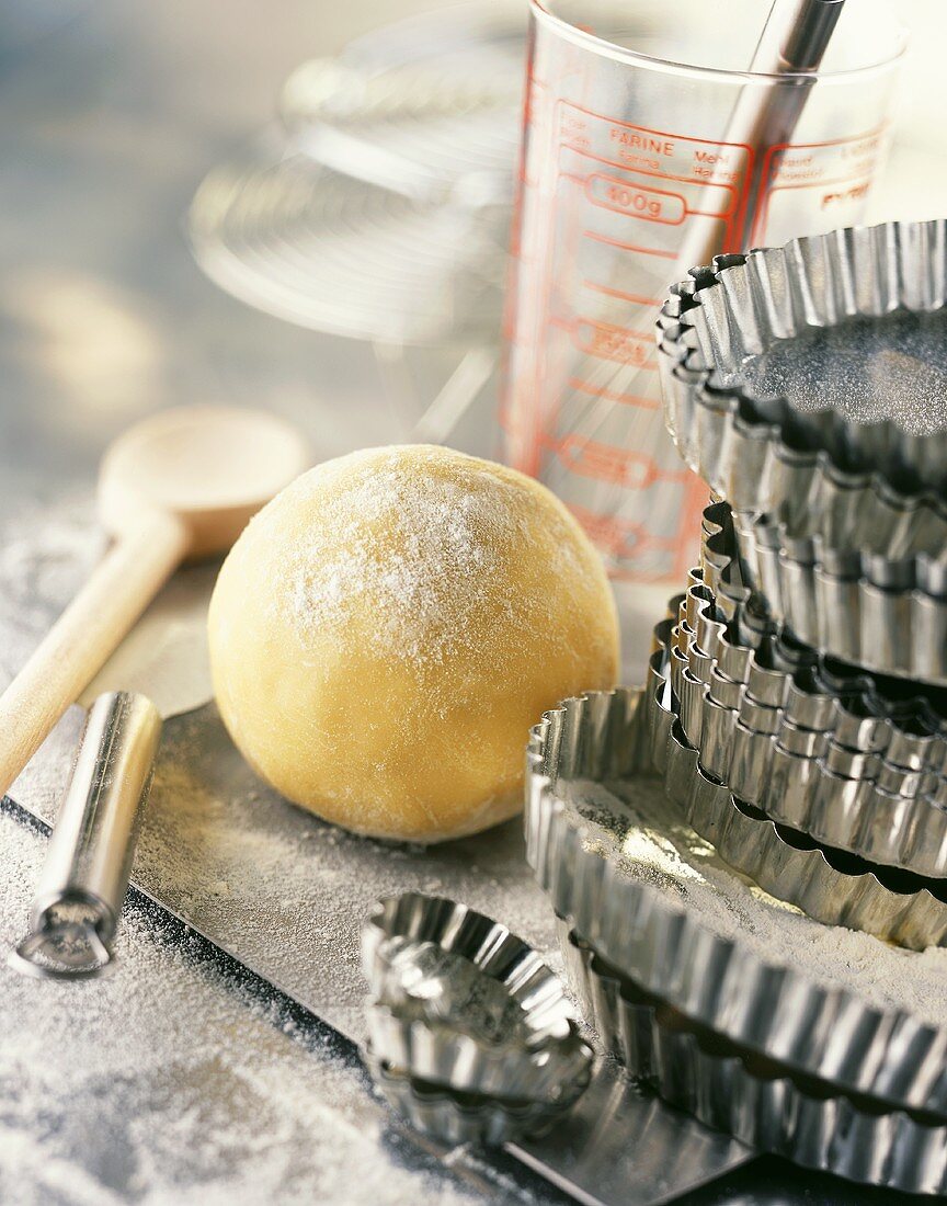 Still life with ball of pastry and various baking utensils