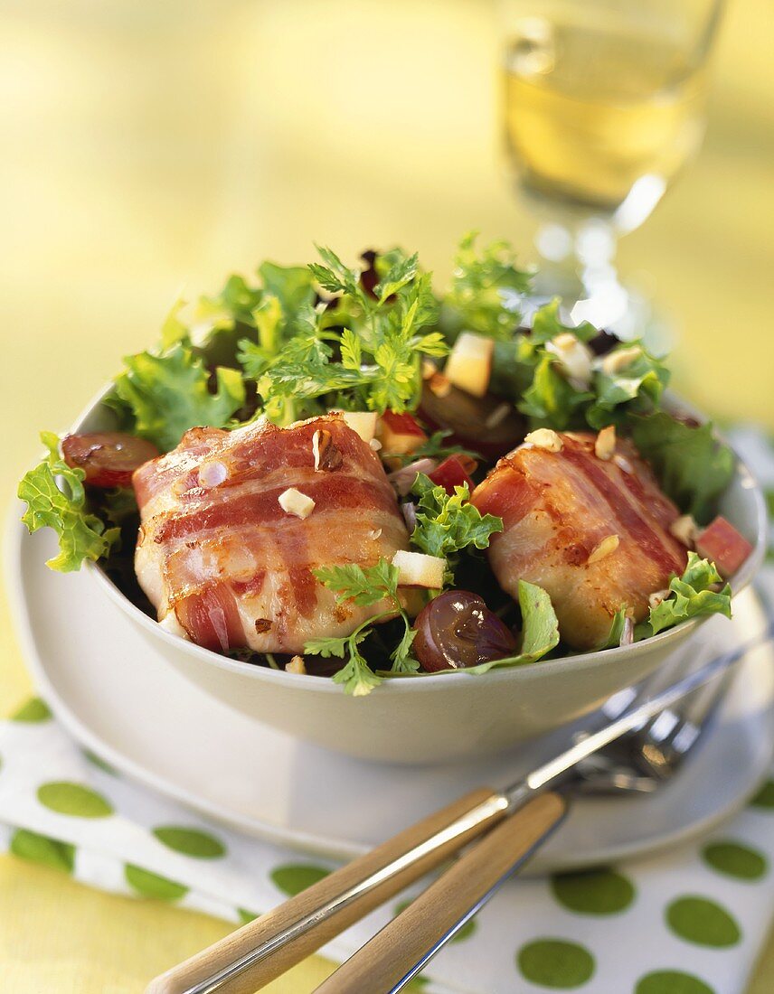 Goat's cheese wrapped in bacon on salad leaves