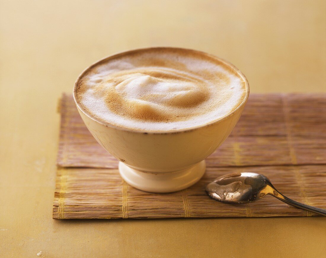 Milky coffee in a bowl, coffee spoon