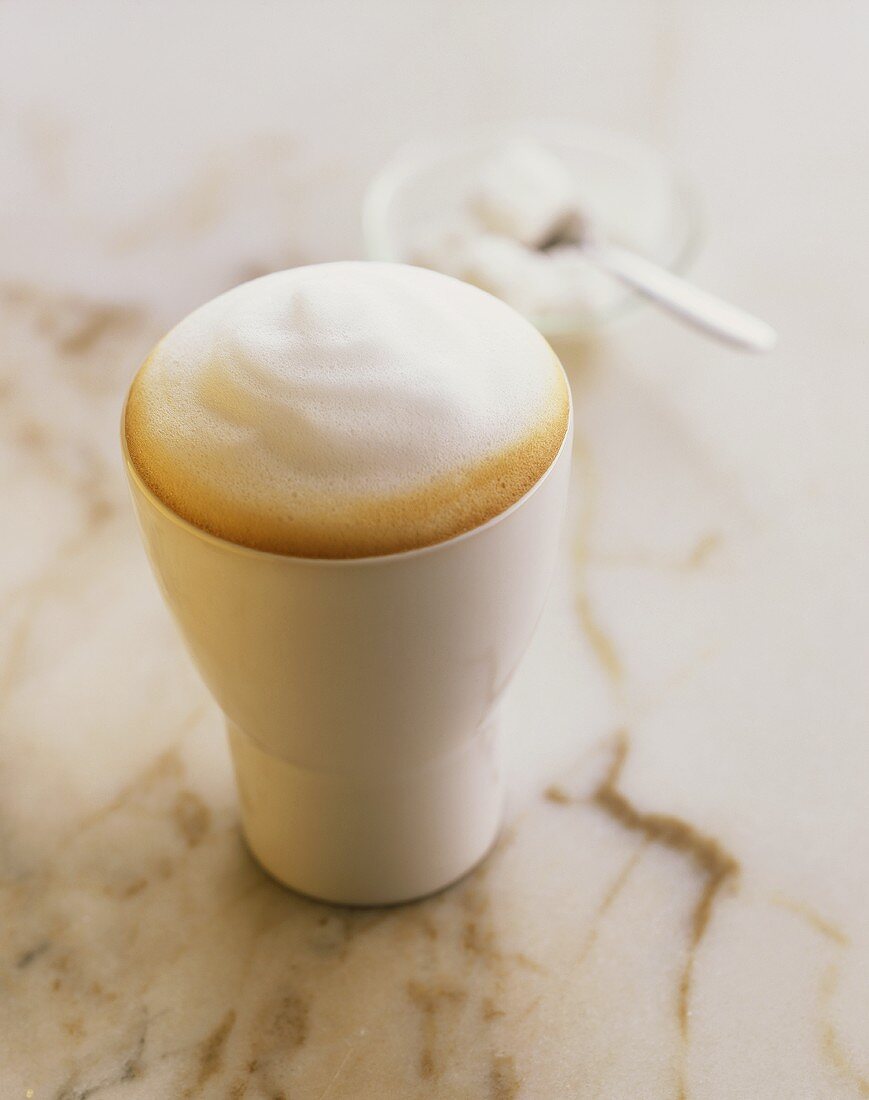 Latte macchiato in white pottery beaker
