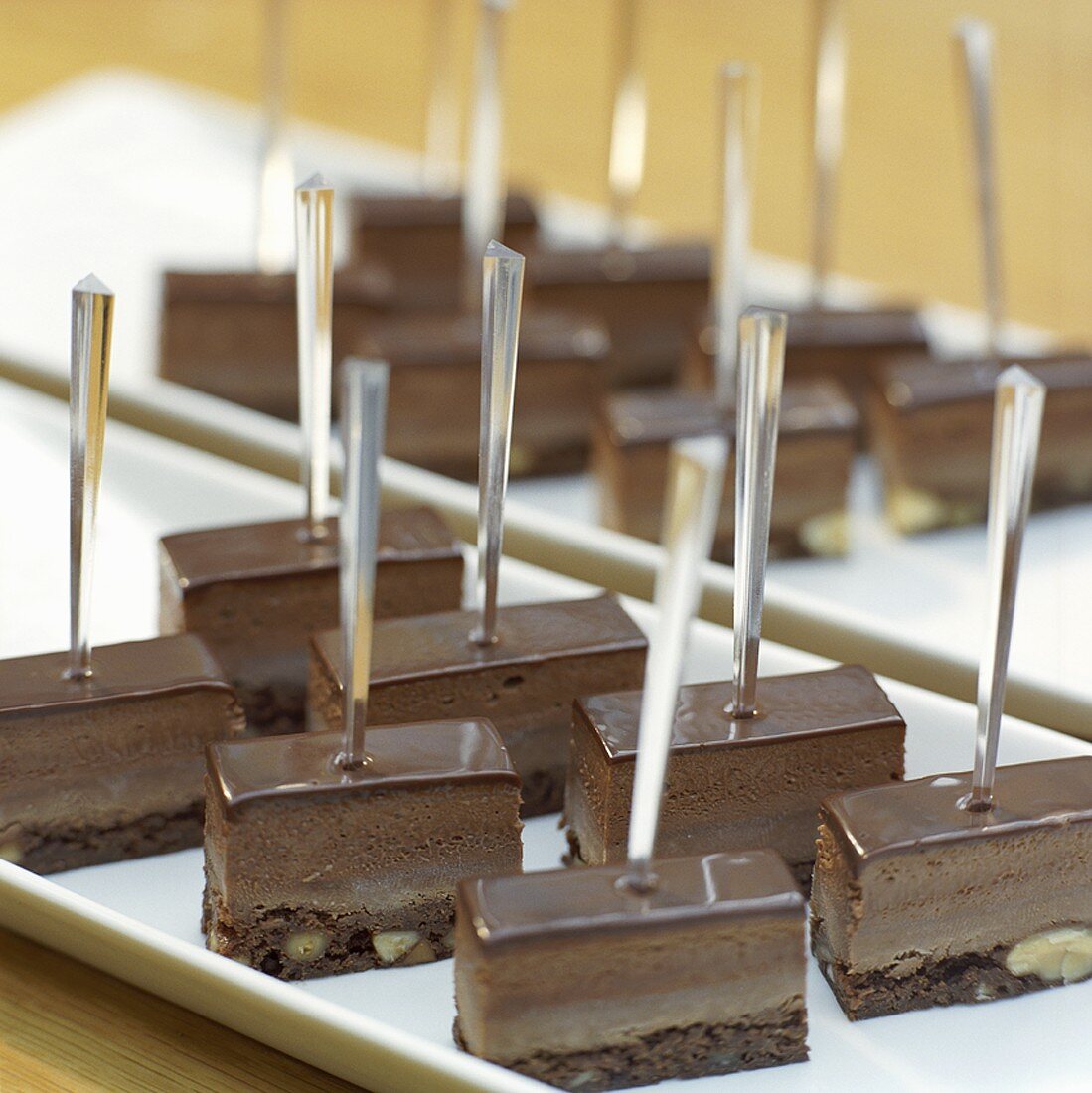 Pieces of chocolate cake on cocktail sticks on a buffet