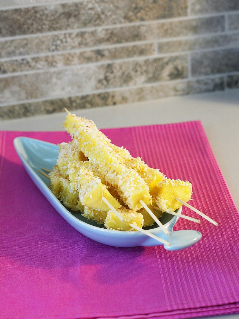 Pineapple skewers with grated coconut