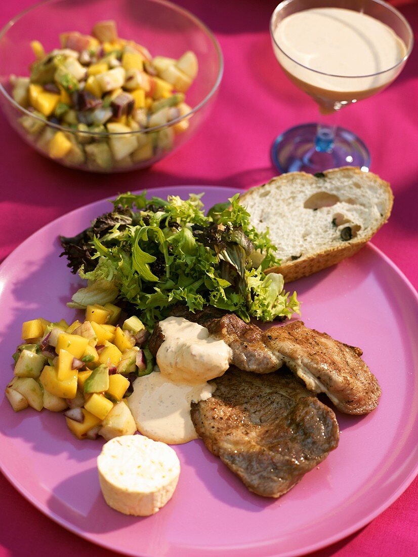 Grillteller mit Fleisch, Sambalsauce und Avocado-Mango-Salat