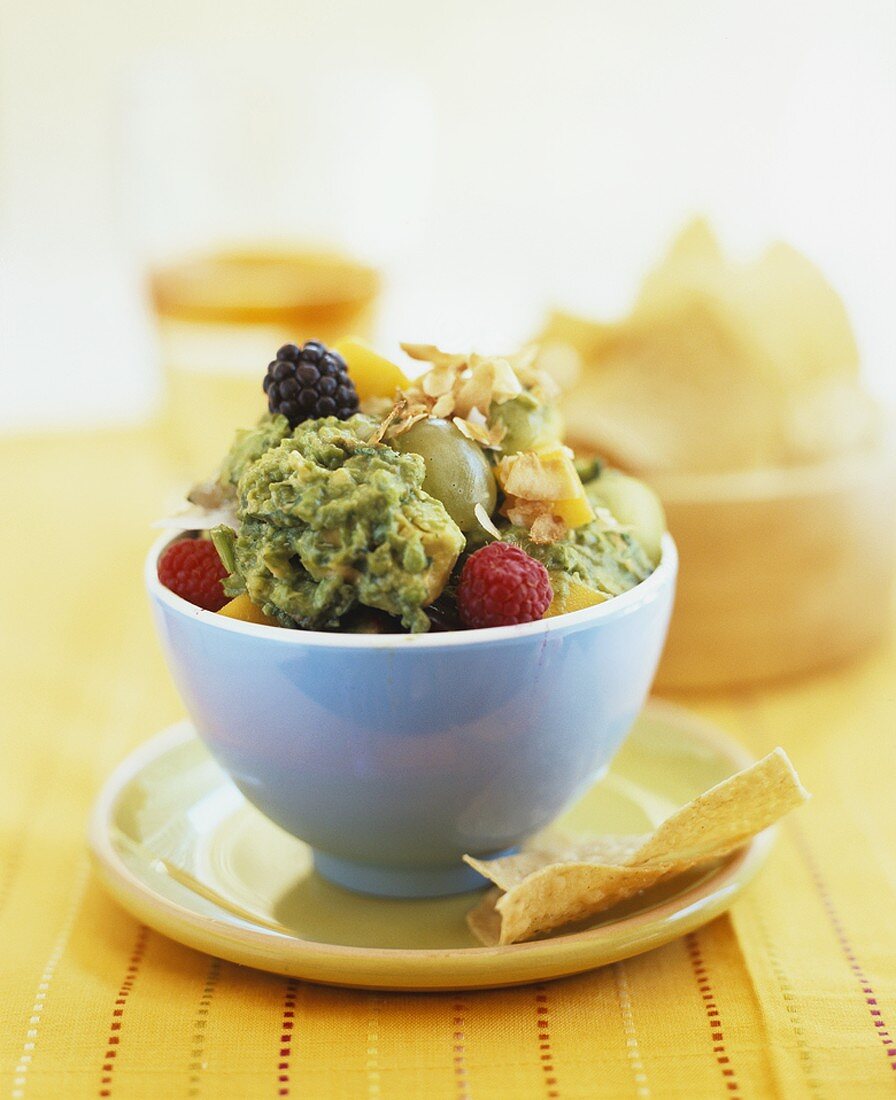 Avocado cream with mango, berries, grapes and crisps