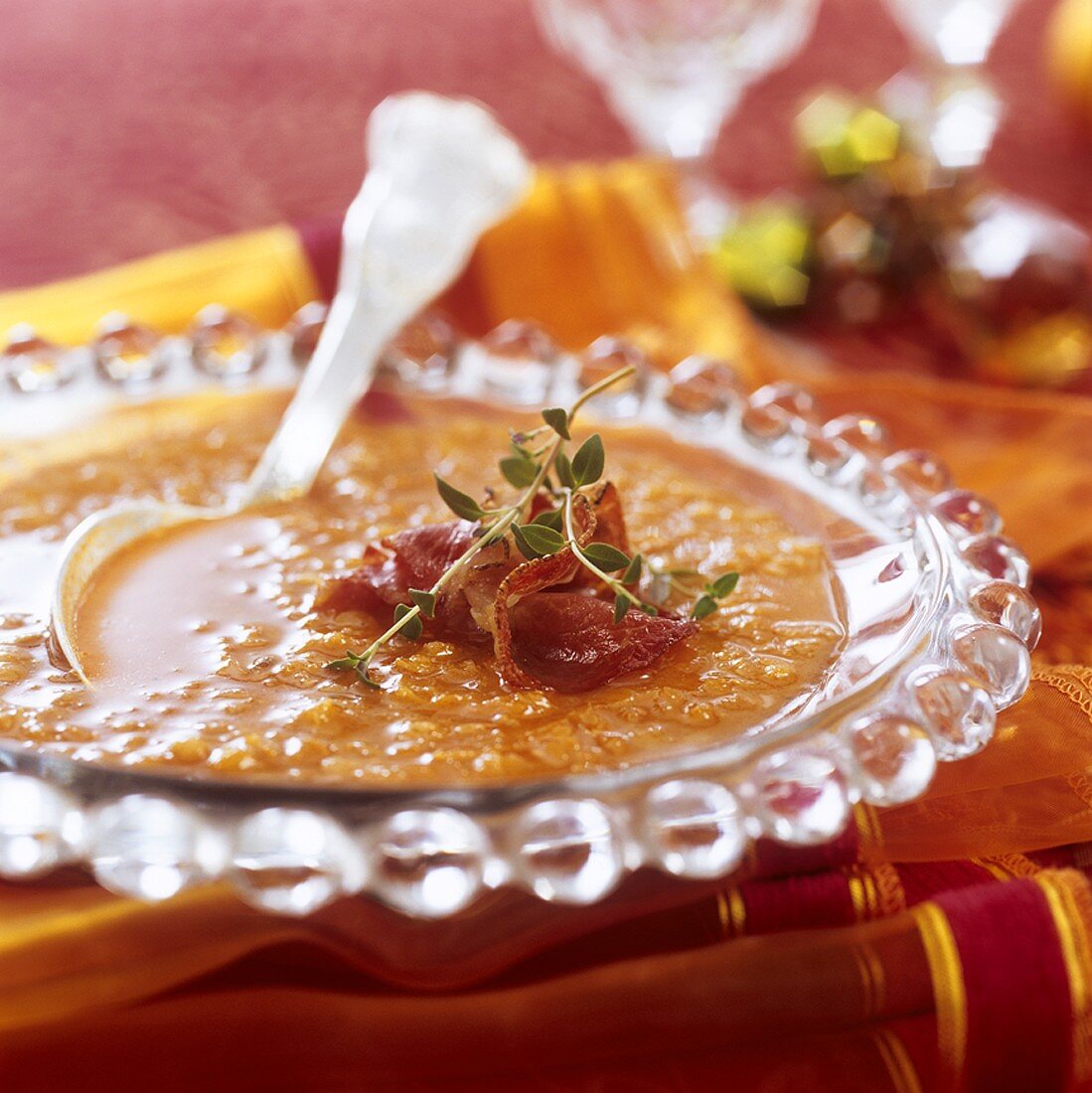 Red lentil soup garnished with schinkenspeck (cured pork) & thyme