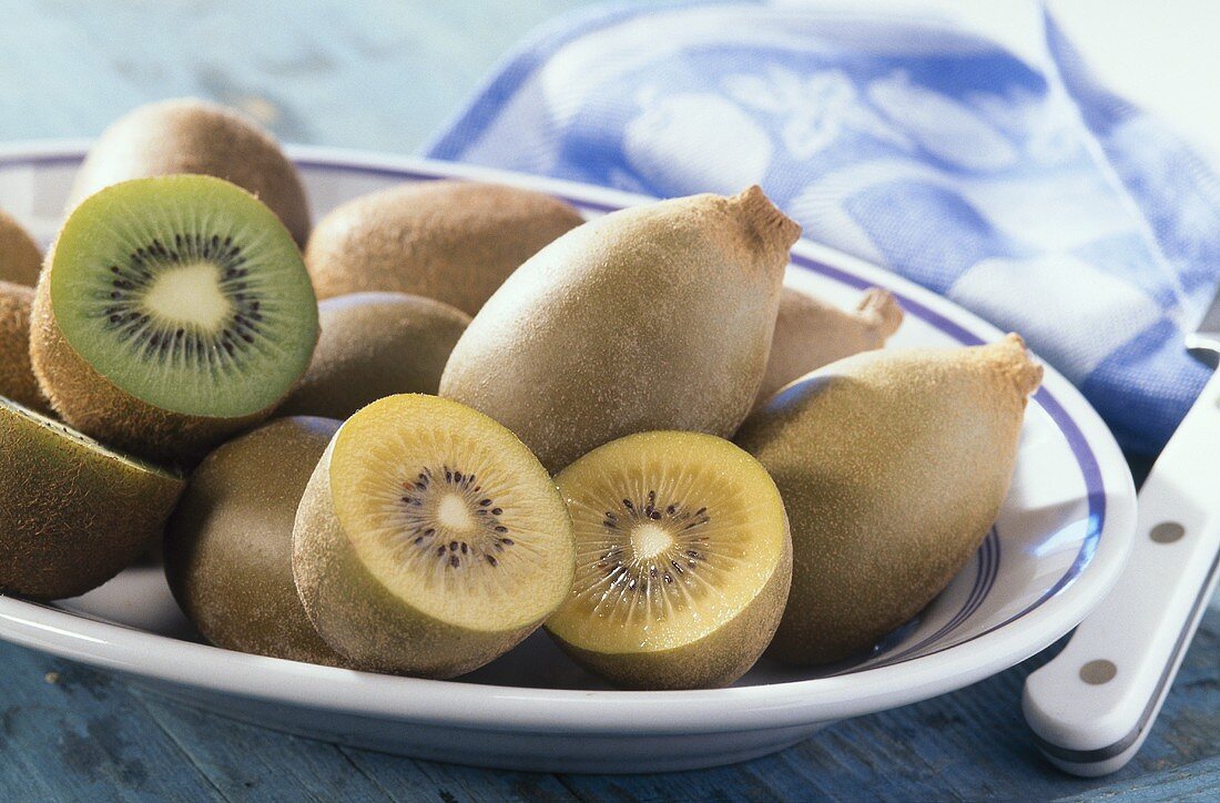 Half and whole kiwi fruits on a platter